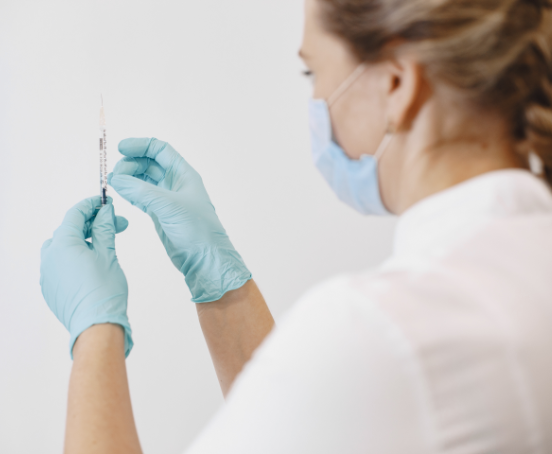 Pielęgniarka trzymająca strzykawkę w ręce.